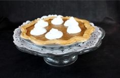 a pie sitting on top of a glass cake plate