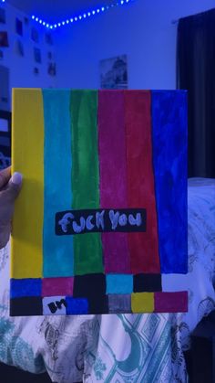 a person holding up a piece of art made out of colored paper with the words rock you on it