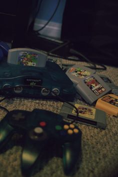 two video game controllers sitting next to each other on the floor in front of a television