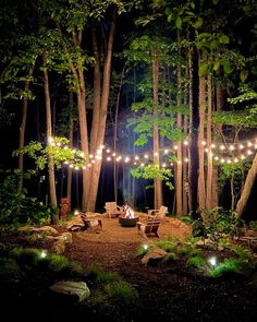 an outdoor fire pit surrounded by trees and lights