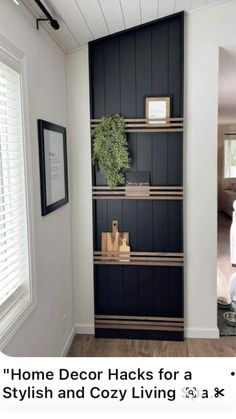 a living room with black bookcases and white walls