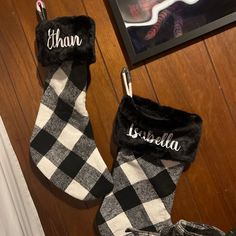 two personalized christmas stockings hanging on the wall next to a pair of slippers