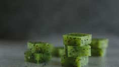 several pieces of green fruit sitting on top of a table