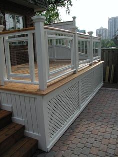 an outdoor deck with white railings and wooden steps