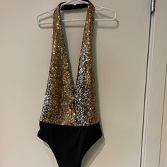 Flattering Low Cut Sequin Body Suit In Gold And Black. Halter With No Back. Never Been Worn! New With Tags Glamorous Backless Party Swimwear, Spring Party Backless Bodysuit, Chic Sequined Bodysuit For Night Out, Chic Bodysuit For Club And Party Season, Glamorous Halter Neck Swimwear For Party, Glamorous Stretch Swimwear For Party, Chic Bodysuit For Date Night And Party Season, Trendy Backless Party Bodysuit, Trendy Backless Bodysuit For Party