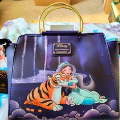 This Is An Awesome Looking Loungefly Disney Jasmine Handbag. The Colors Are Awesome, The Front Art Work Of Is Beautiful. It Has A Large Zipper Compartment And It Comes With An Adjustable Strap. If You Are An Jasmine Fan You Need This Bag Themed Purple Travel Bags, Disney Blue Shoulder Bag For Travel, Blue Disney Bags For Gifts, Disney Travel Bags With Detachable Strap, Disney Bags For Daily Use, Disney Style Shoulder Bag With Removable Pouch, Disney Style Shoulder Bag For Everyday Use, Daily Disney Style Bag, Disney Rectangular Bags For Disney Fan Events