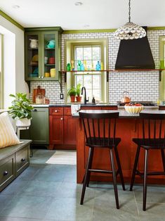 a kitchen with two stools next to an island