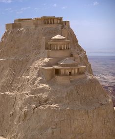 an ancient building built on top of a cliff in the middle of the desert with no people around it