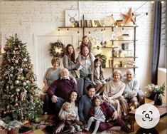 a group of people sitting in front of a christmas tree