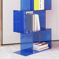 a blue shelf with books on it in front of a white wall and carpeted floor