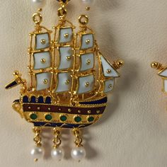 Museum copy caravel shaped earrings made of 18 ct. solid yellow gold decorated with colorful handmade hot enamel and pearls, made in Greece in Athens Each earring is made of 33 different pieces, as you can see in the photo, most of the pieces are different between the left and the right earring It' s a perfect reproduction of an antic pair of earrings The original is exposed at the Benaki museum in Athens and belongs to the most famous and discussed jewelry in Greece Post - Byzantine and modern Etruscan Jewelry Earrings, Egypt Earrings, Ancient Greek Earrings, Etruscan Jewelry Romae Jewelry, Ancient Greek Jewelry Museum Of Jewelry, Benaki Museum, Ancient Greek Coin, Greek Coins, Clip On Charms