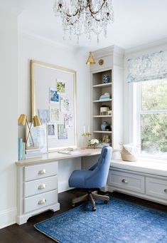 a blue chair sitting in front of a desk with a chandelier above it