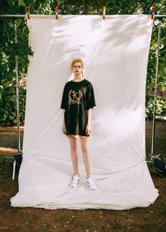 a woman standing in front of a white backdrop