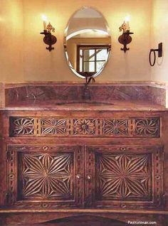 an ornate wooden cabinet with mirror above it