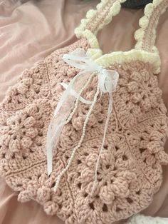 a crocheted purse is laying on a bed