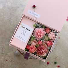 a pink box filled with flowers on top of a table