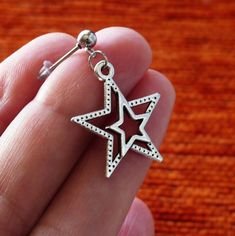 Star earrings. Antique silver tone star charms dangling on stainless steel earring studs with rubber backs. Star size: 23mm x 20mm This listing is for one pair of star earrings with rubber backs. These earrings will come in a gift bag. I offer combined shipping costs which give you a shipping discount for ordering multiple items from my shop. Charm material: Zinc alloy, Nickel safe, Lead free, Cadmium free Earrings care: Take them off while you sleep, sports activities, bathing, having a shower. Silver Star Earrings With Charms, Nickel-free Star-shaped Silver Piercings, Nickel Free Silver Star-shaped Piercing, Silver Star-shaped Pierced Cartilage Earrings, Silver Star-shaped Cartilage Earrings With Pierced Design, Silver Star Single Stud Earring, Silver Internally Threaded Dangle Cartilage Earrings, Nickel-free Silver Star Piercings, Nickel Free Silver Dangle Piercings