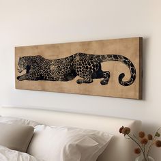 a leopard painting on the wall above a bed