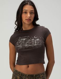 Billabong Lost Desert Baby Tee. Large Graphic Screened On Front. Ribbed Crew Neckline. Short Sleeve. Shrunken Fit. 100% Cotton. Machine Wash. Imported. Model Is Wearing A Size Small. Model Measurements:height: 5'8" Bust: 32"waist: 24"hips: 35" Cheap Gap T-shirt With Screen Print, Billabong Graphic Tees, Graphic Print Relaxed Fit Crop Top, Grunge Lifestyle, Wwe T Shirts, Graphic Trends, Boho Tees, Baby Graphic Tees, Girls Graphic Tee