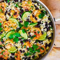 a skillet filled with rice, shrimp and black beans