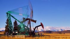 an oil pump in a field with mountains in the background