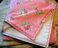 three napkins on top of each other on a marble table with pink and green flowers