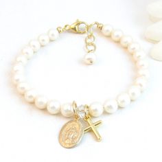 Real Pearl Bracelet with Gold-Filled Virgin Mary/Miraculous Medal Charm and Cross Charm:  Created with: ~ 5.5mm round high-quality freshwater pearls ~ 14K gold-filled 2-sided Virgin Mary charm (measures 1/2" tall and 3/8" wide) ~ 18K gold-filled cross charm (measures 1/2" tall and 3/8" wide) ~ Small clear crystal separates the charms ~ 14K gold-filled lobster clasp with an attached 1/2" 14K gold-filled "Grow with Me" extender chain ~ Other metal components are 14K gold-filled.   The pearls are strung on super strong, stainless steel gold colored wire for extra durability (not stretchy). Charms can be placed front/center or near the clasp. The small crystal between the charms can be any color! Use the notes to seller at checkout if you would prefer a birthstone color. Arrives tucked inside Confirmation Jewelry, Real Pearl Bracelet, Real Pearl Earrings, Jewelry Girl, 1st Communion, Girl Christening, Birthstone Colors, Miraculous Medal, Gold Initial