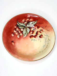 a plate with berries and leaves painted on it