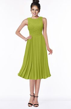 a woman in a green dress posing for the camera with her hands on her hips