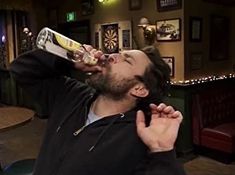 a man drinking from a bottle in a bar