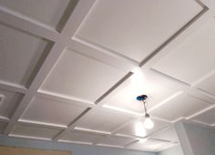 an empty room with white walls and ceiling tiles