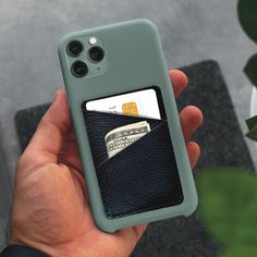 a person holding up a wallet case with a credit card in it