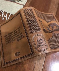 a leather wallet sitting on top of a wooden table next to a rug with writing on it