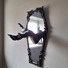 a mirror hanging on the side of a wall next to a person's reflection