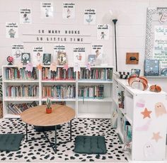 a room filled with lots of books next to a white book shelf full of children's books