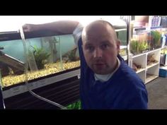 a man is taking a selfie in front of an aquarium