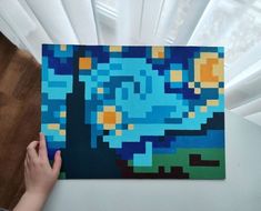 someone is holding up a piece of art that looks like the starry night