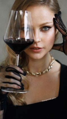 a woman holding a glass of red wine