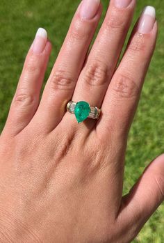 This ring presents a sophisticated blend of elegance and luxury, showcasing a 3.22 carat pear-shaped natural Colombian emerald center stone. Adorned with 0.66 CTTW in baguette-cut diamond side stones. The center stone is set in a 3-prong setting with an open back, allowing the emeralds vivid green hue to radiate brilliantly and securely.  Item Details: - Type: Ring  - Metal: 18K Yellow Gold  - Weight: 8.0 Grams  - Setting: 3-Prong  - Size: 7 (adjustable) Emerald Details: - Carat: 3.22  - Cut: Pe Fine Jewelry Pear-shaped Emerald Ring Vvs Clarity, Fine Jewelry Pear-shaped Emerald Ring With Vvs Clarity, Elegant Heart Cut Emerald Ring, Pear-shaped Emerald Ring For Anniversary, Luxury Pear-shaped Brilliant Cut Emerald Ring, Pear-shaped Emerald Anniversary Ring, Pear-shaped Brilliant Cut Emerald Ring, Luxury Pear-shaped Emerald Ring With Prong Setting, Formal Pear-shaped Emerald Fine Jewelry Ring