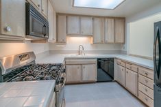 an empty kitchen with stainless steel appliances and wood cabinets