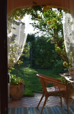 an open door to a small patio with chairs and table in the middle of it