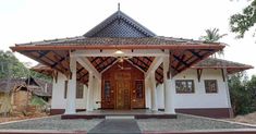 a white and brown building with a wooden door on the front entrance to it's side