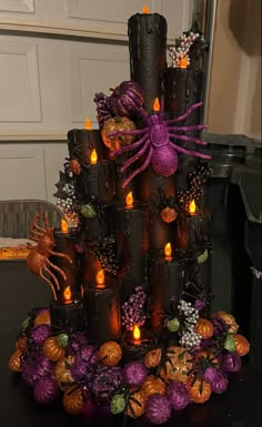 a halloween tree made out of candles and candy wrappers with spider decorations on it