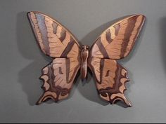 a wooden butterfly is hanging on the wall