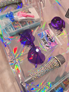 various items are displayed in plastic bags on a table with holographics and beads