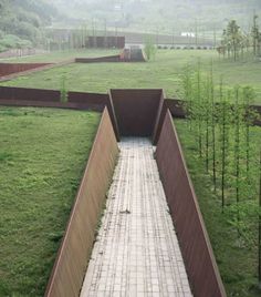 an empty walkway in the middle of a grassy field