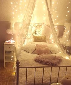 a bed with white sheets and lights on the headboard is shown in this instagram