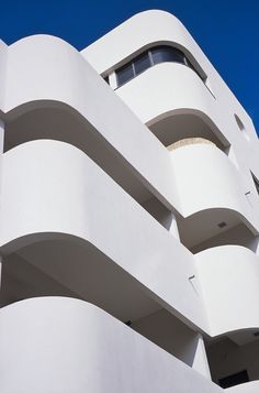 an architectural building with curved balconies against a blue sky