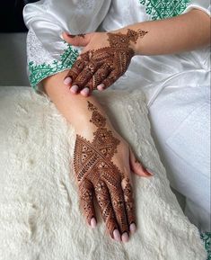 two hands with henna tattoos on them