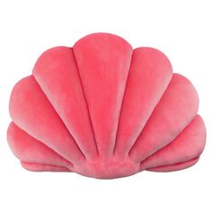 a pink scallop shaped pillow sitting on top of a white surface